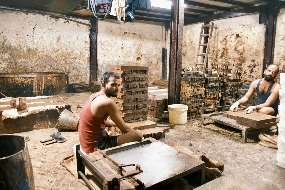 Habitant de Dharavi à Mumbai en plein travail, illustrant la vie locale durant un voyage hors des sentiers battus. 